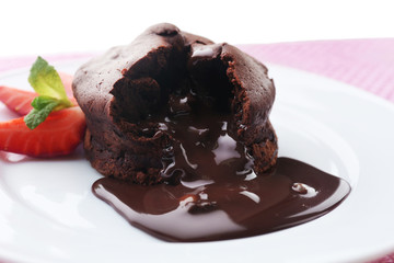 Chocolate fondant with strawberries on white plate, closeup