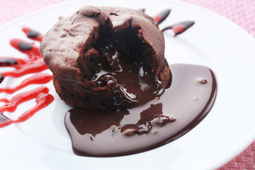 Chocolate fondant with strawberry cream on white plate, closeup