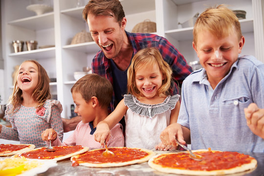 Father making pizza with his kids