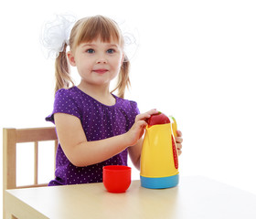 Cute little girl sitting at a table 