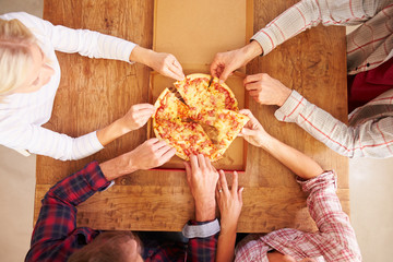 Friends sharing a pizza together, overhead view