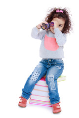 Little girl sitting on a stack of books