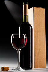 Wine bottle with box and filled glass of wine