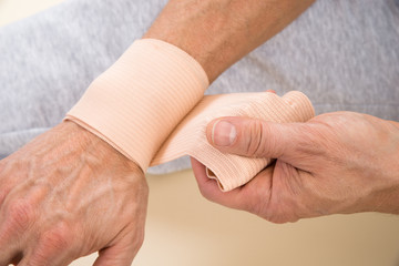 Man Tying Bandage To His Wrist