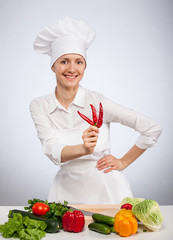 Young smiling female cook preparing salad