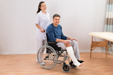 Doctor With Disabled Patient On Wheelchair
