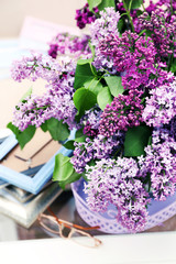 Beautiful lilac flowers in vase on table of interior background