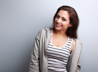 Happy young casual woman with smile on blue background