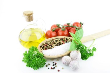 Salt and Pepper on a big wooden spoon, with some herbs around it. On a white background.