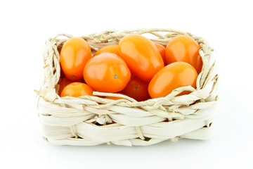 Orange tomatoes in a woven basket.