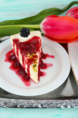Tasty piece of cheesecake with berry sauce on plate on table close up