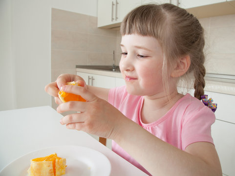 Happy Little Girl Eating A Tasty Orange