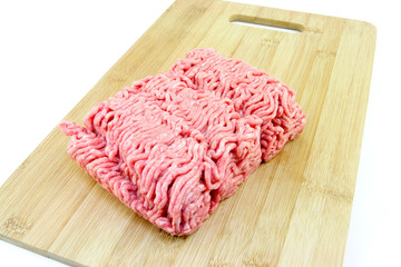 A block of minced meat on a wooden chopping board