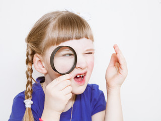 Funny little girl with loupe