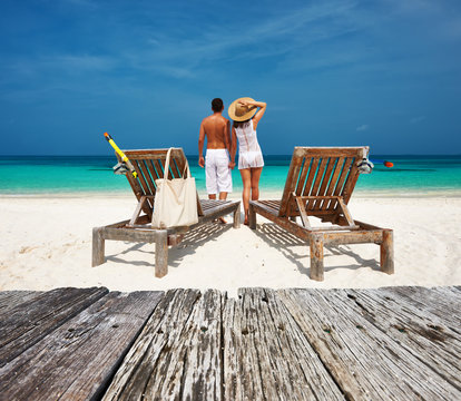 Couple in white relax on a beach at Maldives