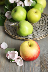 Fresh apples with apple blossom on wooden table