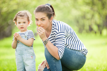 Portrait of a beautiful young woman with a small child in park