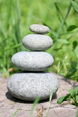 Obraz na płótnie Canvas Stack of spa stones over green grass background