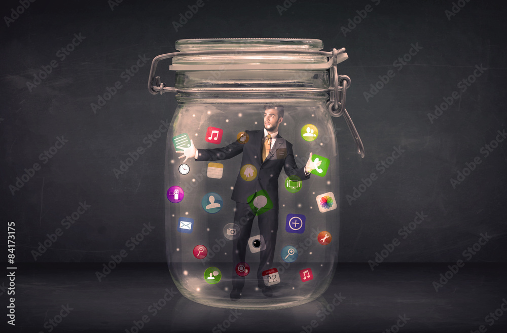 Wall mural Businessman captured in a glass jar with colourful app icons con