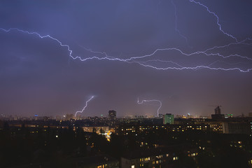 Naklejka na ściany i meble lightning strikes over night town during a thunderstorm. Kiev, U