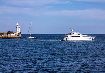 Yalta, Crimea, Russia. Tourist yacht and lighthouse.