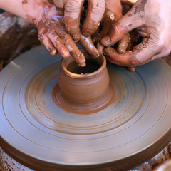 Hands working on pottery wheel