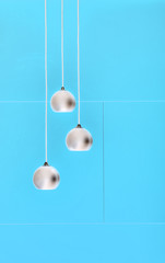 Blue negative collage of three ceiling lights, loft-style interi