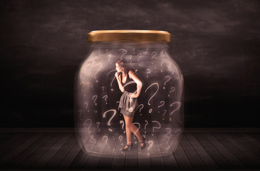 Businesswoman locked into a jar with question marks concept