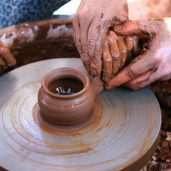Hands working on pottery wheel