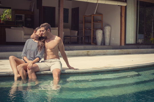 Young love fashion couple near swimming pool at the luxury villa on vacation on a hot day