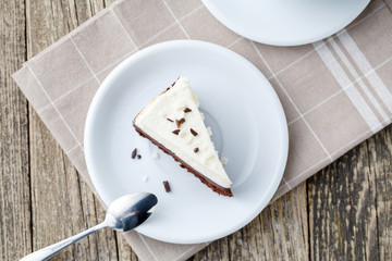 Vanilla cheesecake slice on wooden background.