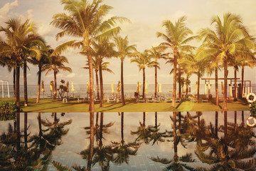 Obraz premium Beautiful palm beach luxury resort with swimming pool in tropics