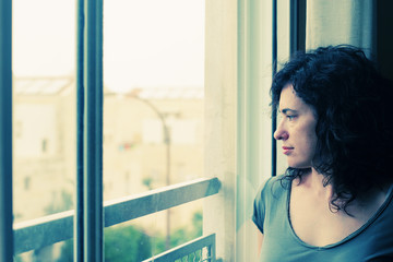 beautiful 35 year old woman stands in front of the window