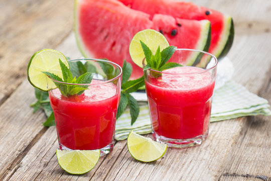 Two glasses with watermelon smoothies with lime and mint
