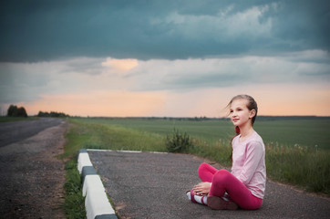 beautiful girl sitting at road