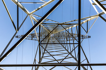 high voltage electricity pylons against blue sky and cloud