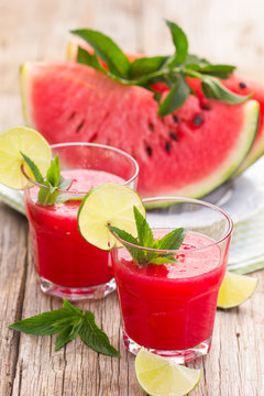 Two glasses with watermelon smoothies with lime and mint