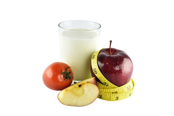 Red apples, measuring tape, glass of milk and tomato on white ba