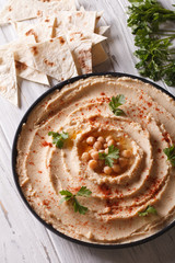 hummus with paprika and parsley on the plate closeup. vertical