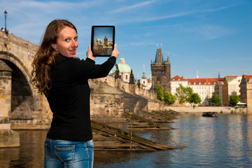 Beautiful young tourist woman photographing sites in Prague Czec