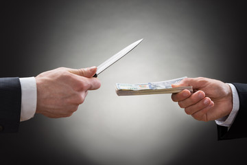 Businessman Giving Money To The Businessperson With Knife