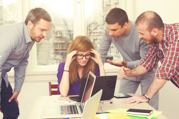 Fototapeta premium Girl got bored from three male co-workers.