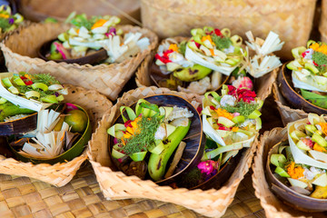Traditional balinese offerings to gods in Bali with flowers and