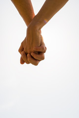 Couple with clasped hands in a closeup conceptual image of love