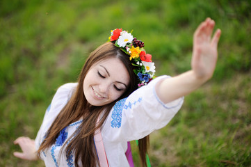 Ukrainian girl in a shirt and a floral wreath on her head pullin