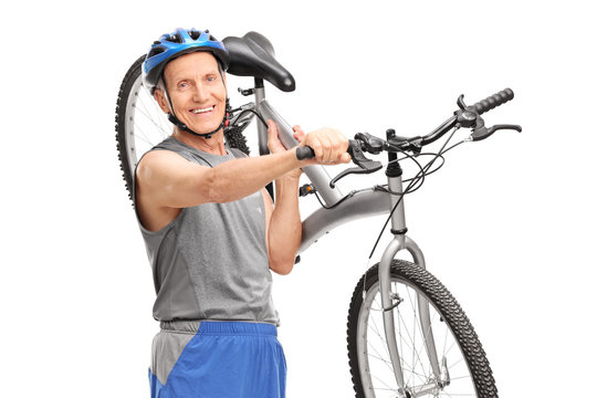 Active senior biker carrying his bicycle over his shoulder and l