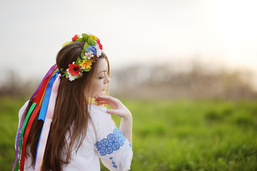 Ukrainian girl in a shirt and a wreath of flowers and ribbons on