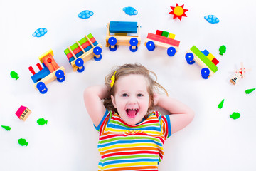 Little girl with wooden train - obrazy, fototapety, plakaty