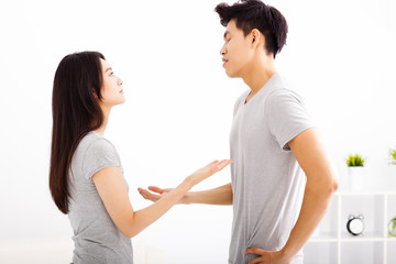 Angry young couple arguing in living room