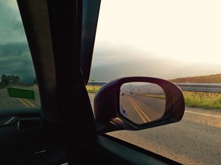Fototapeta premium reflection from car mirror while driving on road